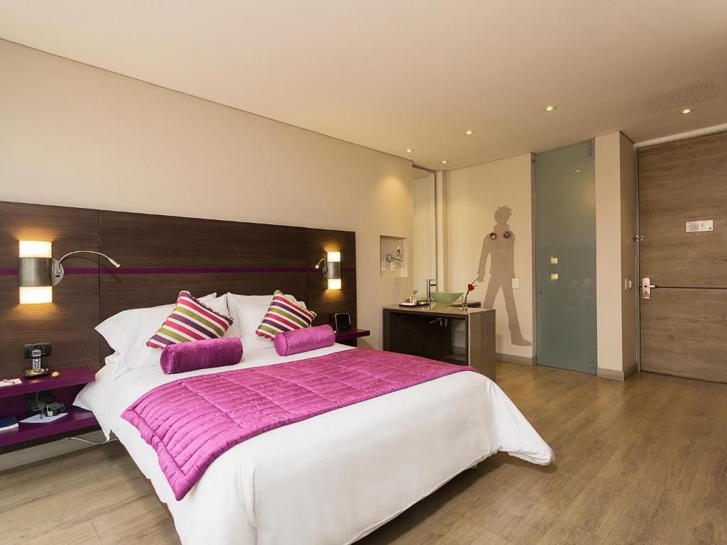 ボゴタにあるMercure Bogota BH Zona Financieraの大きなベッドルーム(紫色の枕が付いた大きなベッド付)