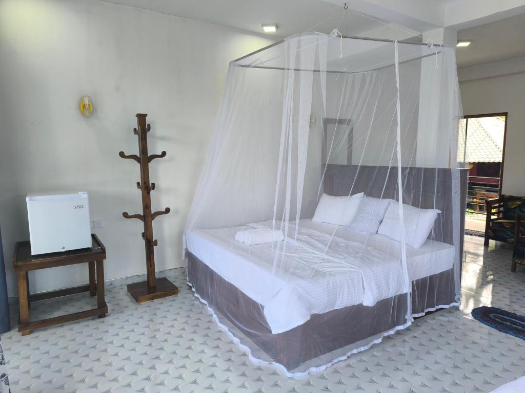 a bed with a canopy in a room at Why Not Guset House Ella in Ella