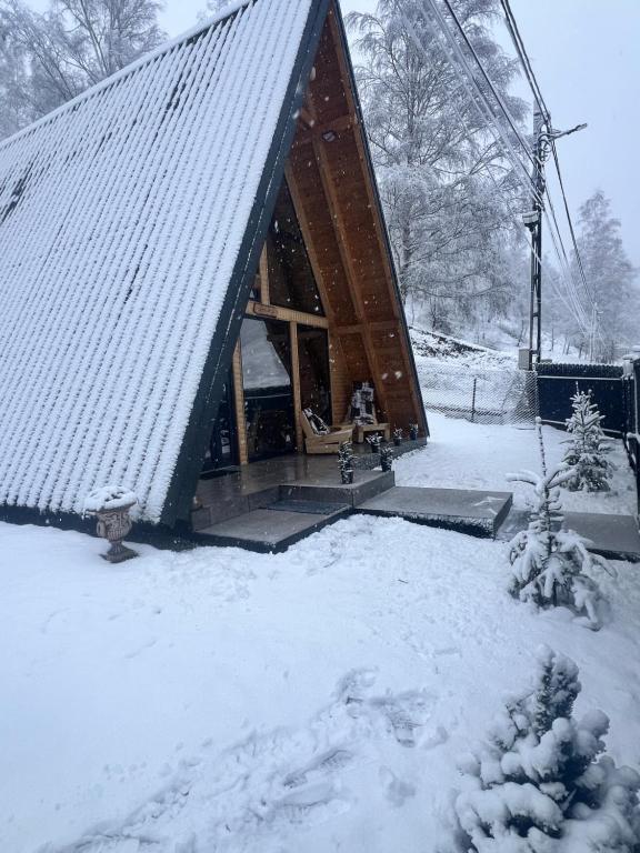 een kleine hut in de sneeuw met een skilift bij Zori de zi in Lupeni