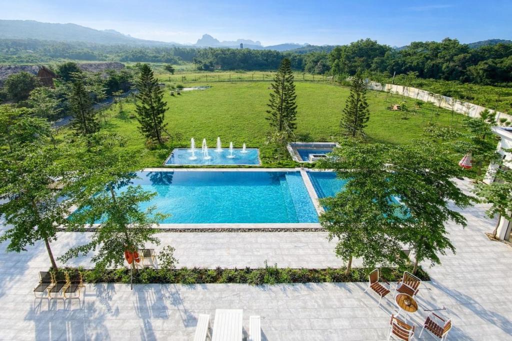 an overhead view of a swimming pool with chairs and trees at Solmist Villa in Hòa Bình