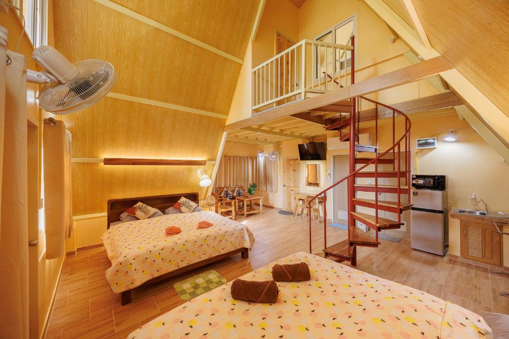 une grande chambre avec deux lits et un escalier dans l'établissement Baandin Chiewlarn, à Ban Tha Khun