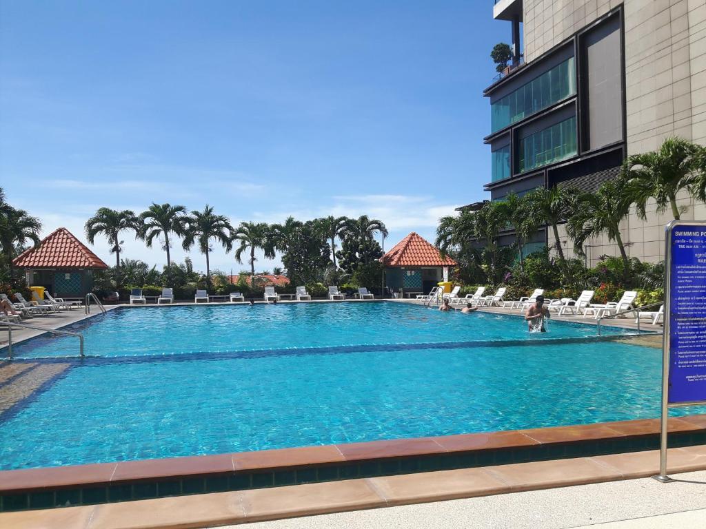 una grande piscina con sedie e un edificio di View Talay6 by Blue Ocean Suite a Centro di Pattaya