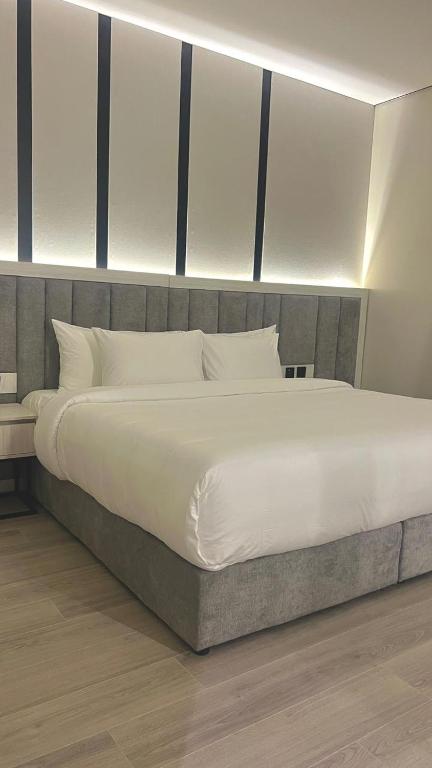 a bedroom with a large bed with white sheets and pillows at Karim Hotel in Dammam