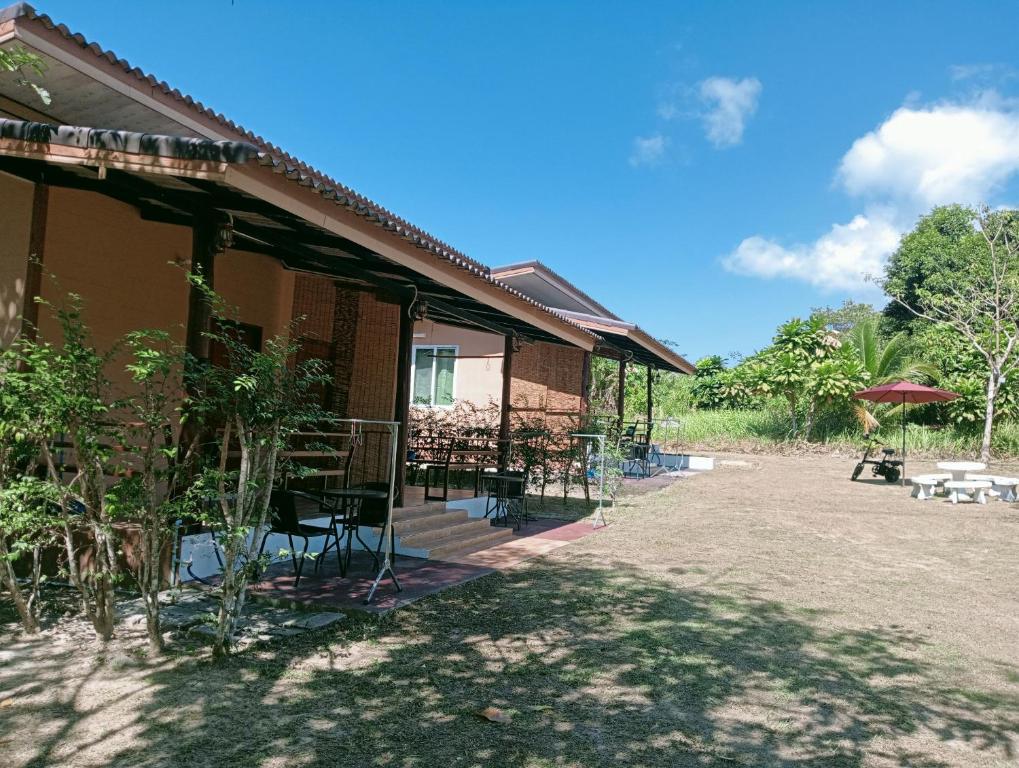 ein Haus mit Stühlen und Tischen außerhalb in der Unterkunft Little Shark bungalow in Ban Bang Bao
