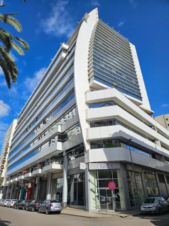 a large building with cars parked in front of it at Casablanca City-Centre Apartment in Casablanca