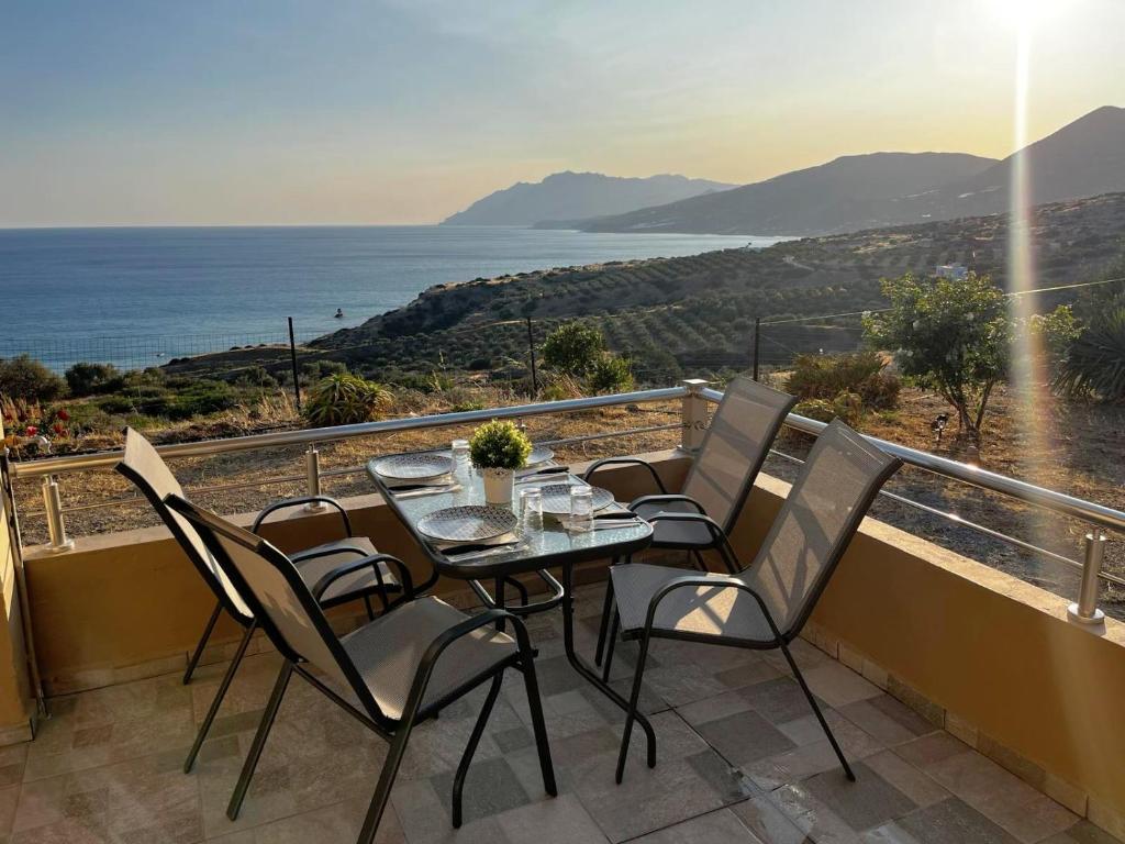 un tavolo e sedie su un balcone con vista sull'oceano di Livikon seaside a Keratokampos