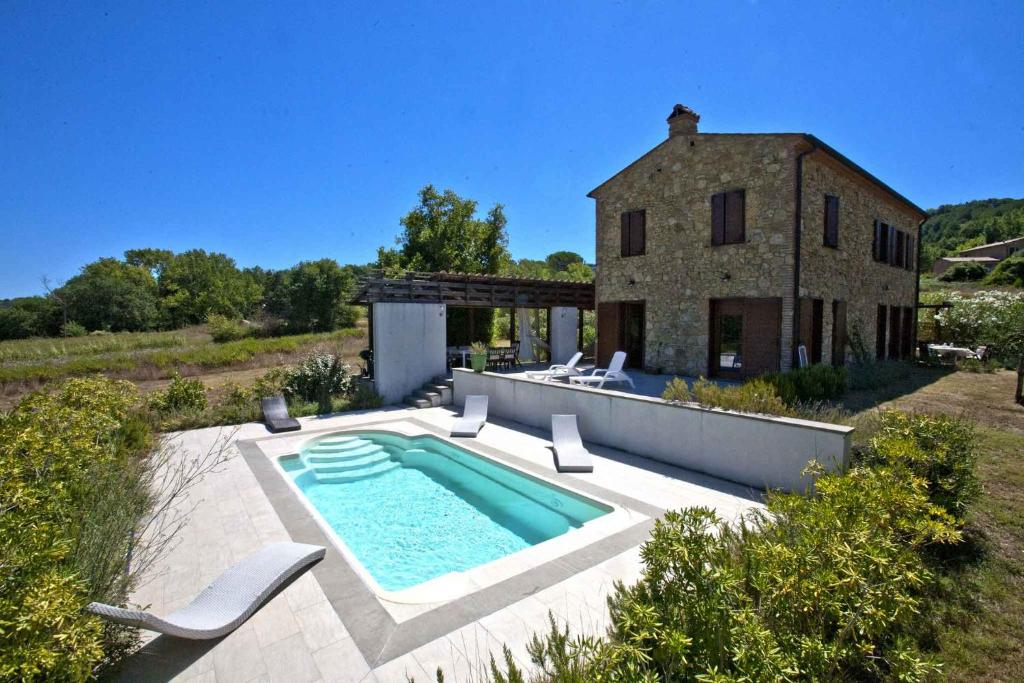 uma vista exterior de uma casa com piscina em Villa Acquaviva em Montescudaio