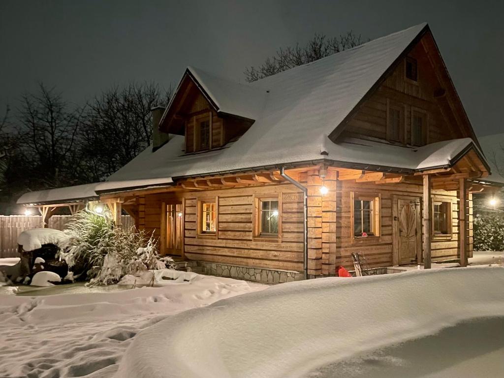 een blokhut met een met sneeuw bedekt dak bij Zacisze Pod Lipą in Andrychów