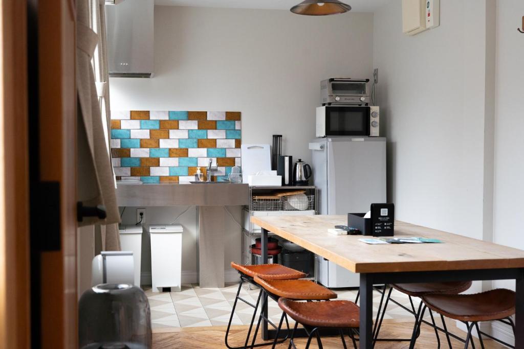 eine Küche mit einem Holztisch und Stühlen in der Unterkunft ROTAN東本町 Omura in Matsue