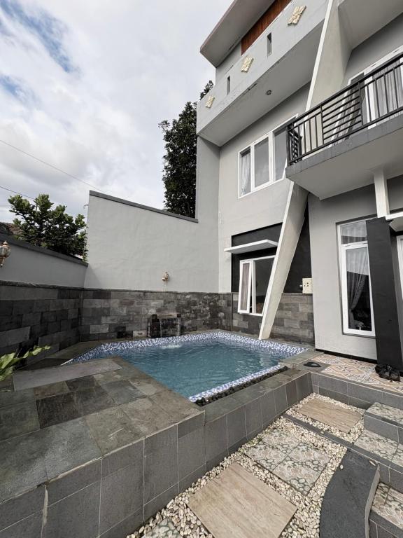 ein Swimmingpool vor einem Haus in der Unterkunft Prabu Villa in Batu