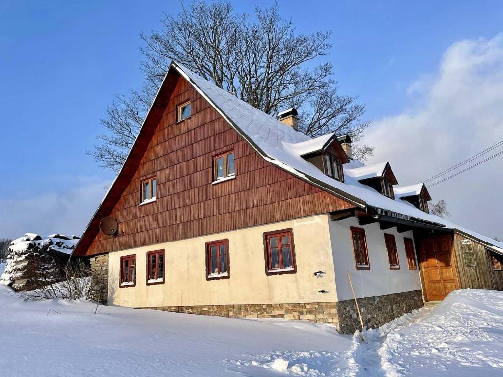 una casa con tetto in legno nella neve di Chalupa u kapličky Říčky v Orlických horách a Wüstenei