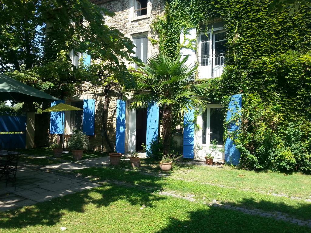 une maison avec de la peinture bleue sur son côté dans l'établissement Le Mas des Platanes, à Entraigues-sur-la-Sorgue