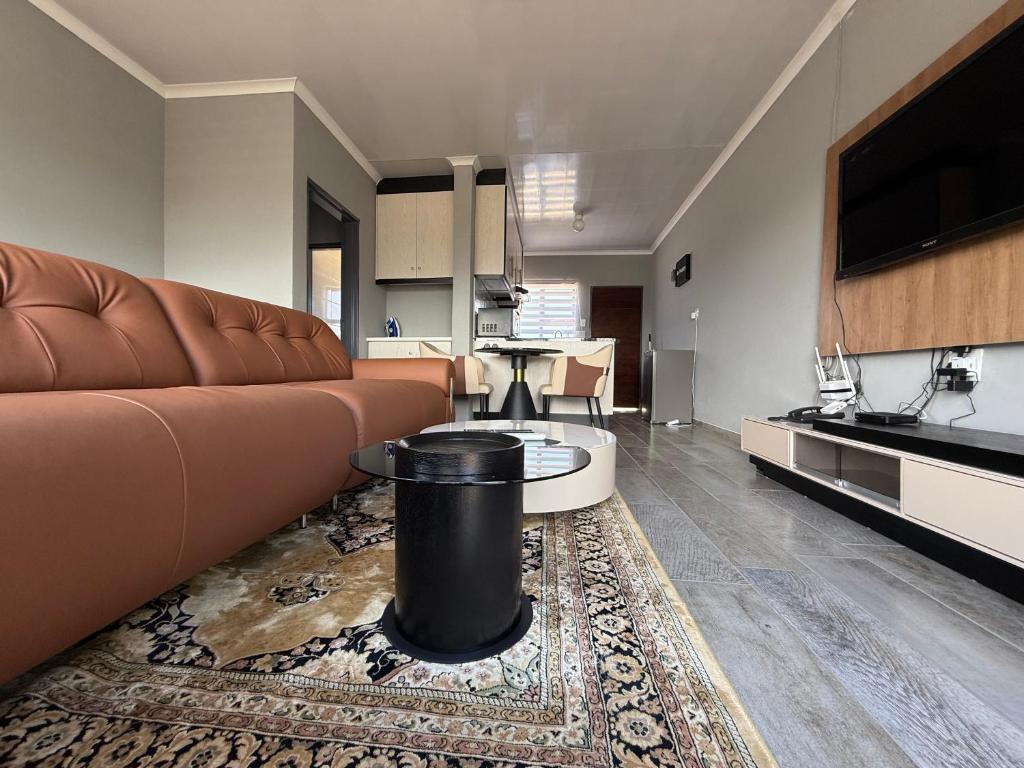 ein Wohnzimmer mit Sofa und Tisch in der Unterkunft The Residence Apartments in Maseru