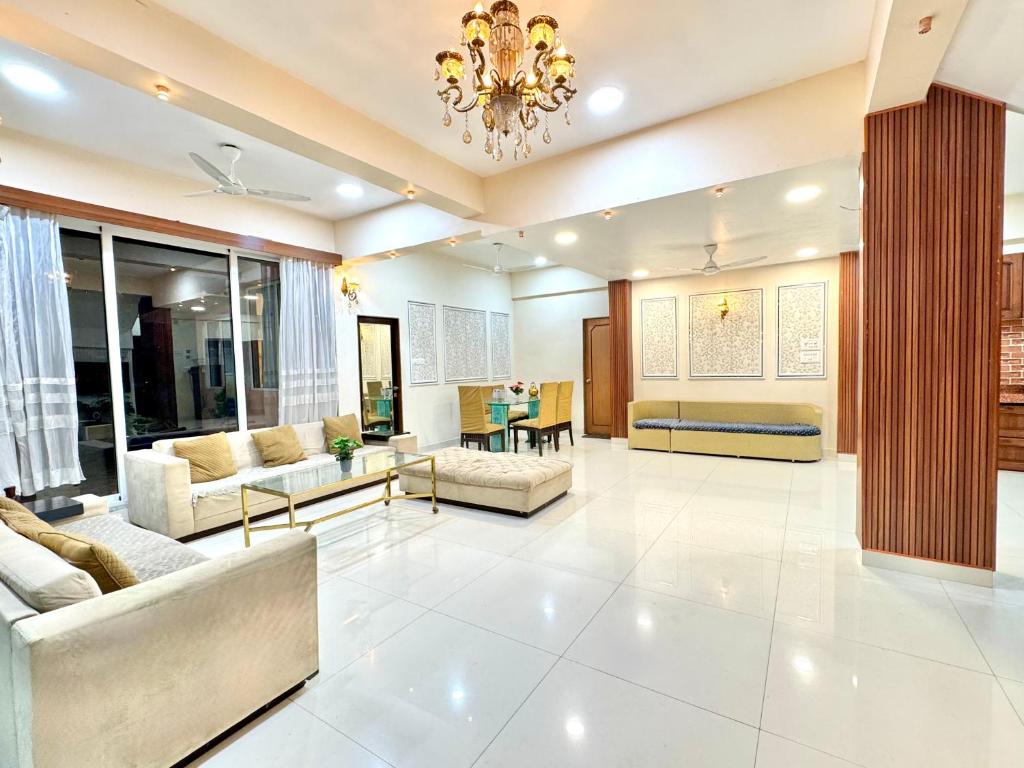 een grote woonkamer met banken en een kroonluchter bij Amy Villa Lonavala - 5bhk- 5 mins from lonavala station with private swimming pool in Lonavala
