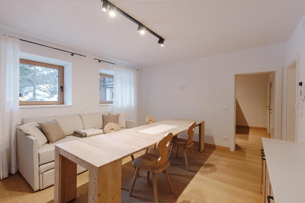 een woonkamer met een tafel en een bank bij Appartamento Borésc in Arabba