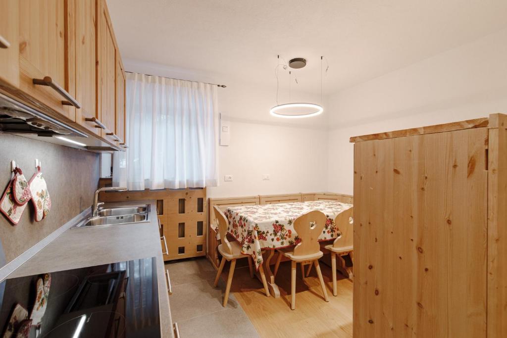 a kitchen and dining room with a table and chairs at Appartamento Borésc - area wellness in Arabba