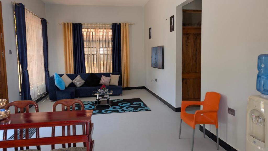 een woonkamer met een blauwe bank en een tafel bij Dans place in Moshi