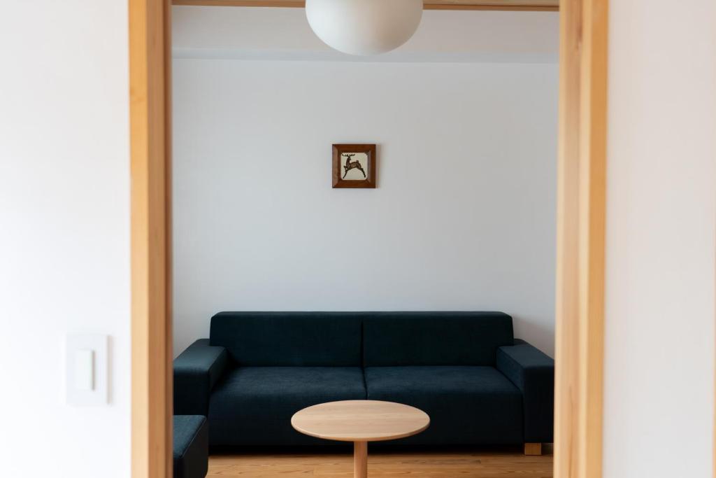 a living room with a blue couch and a table at Rotan寺町 in Matsue