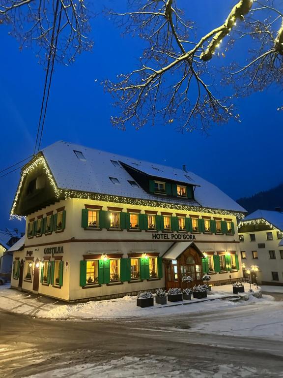 un hotel nella neve di notte di Pod Gora Boutique Hotel a Kranjska Gora