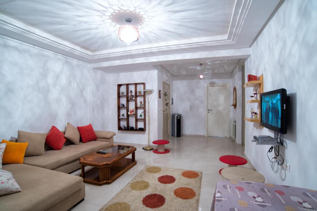 uma sala de estar com um sofá e uma televisão em Résidence Sayadi - Chatt Meriam - Sousse em Port El Kantaoui