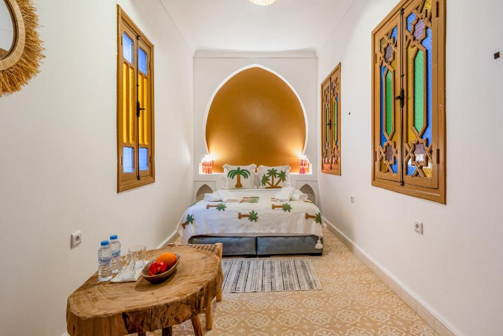 a bedroom with a bed and a table in it at Riad Cherifa Breakfast and Jacuzzi Terrace in Marrakesh
