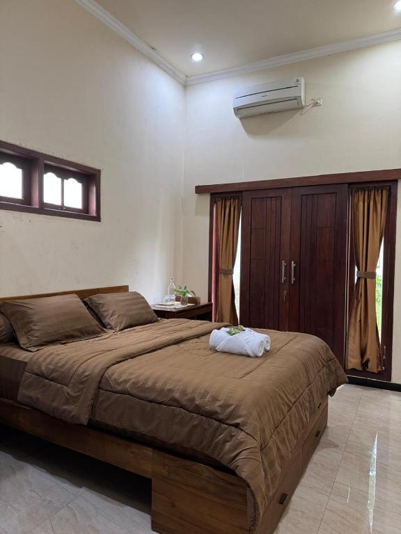 a bedroom with a large bed in a room at Rumah Cahaya Syariah Peaceful Family Home in Rampal