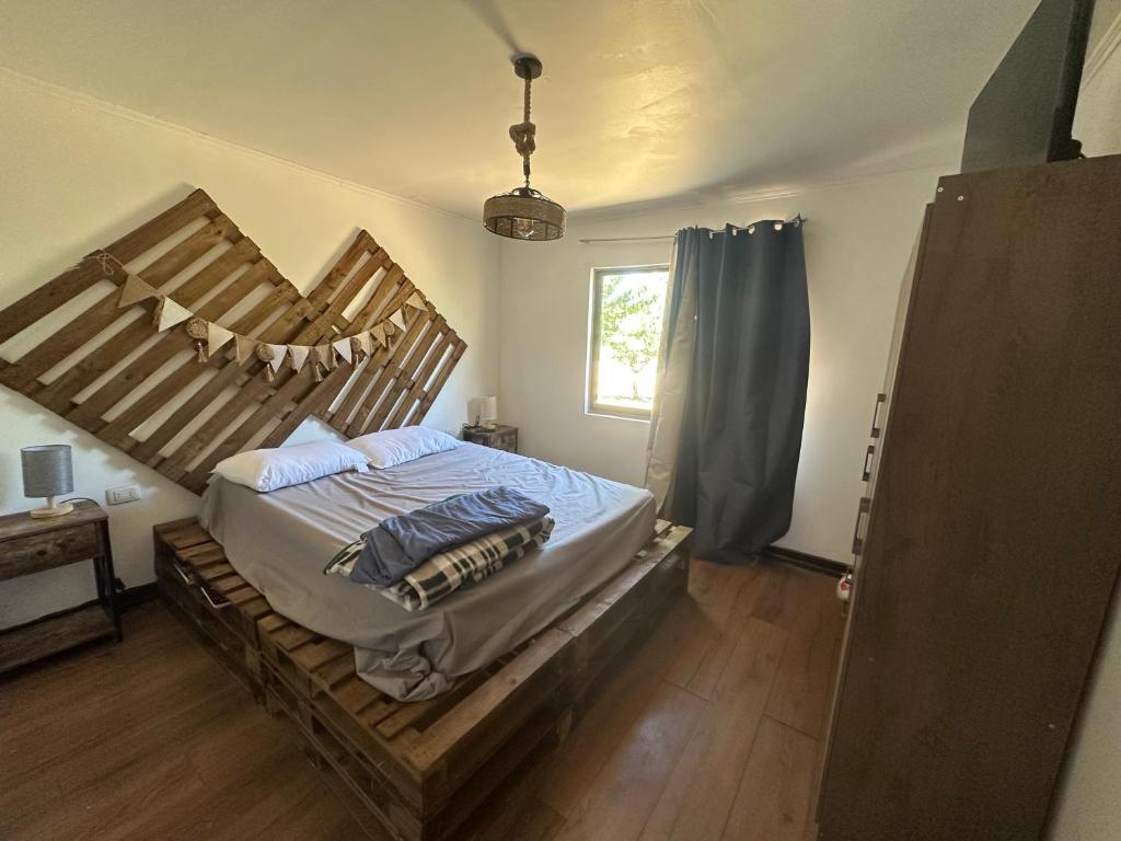 una camera da letto con un letto grande con struttura in legno di Quincho la Beli a Chillán