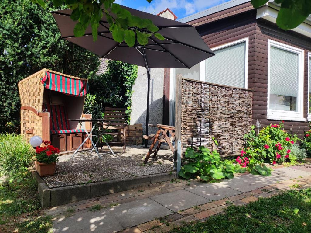 a patio with an umbrella and a table and a grill at Ferienwohnungen am Schwanensee in Plön