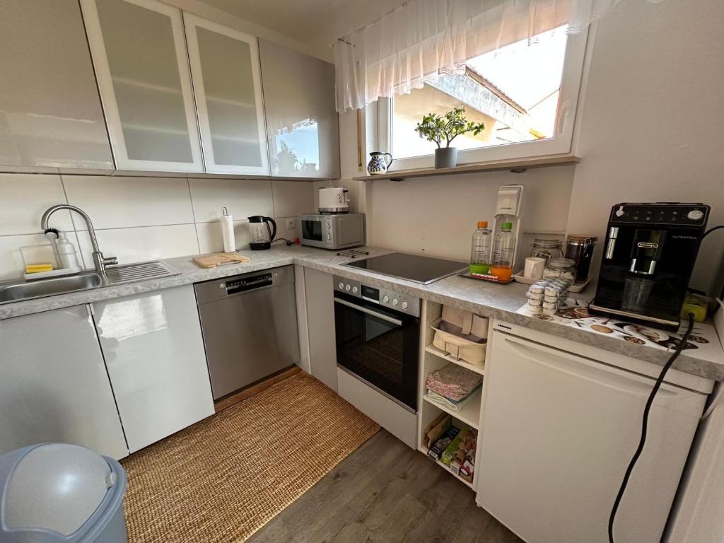 een kleine keuken met witte apparatuur en een raam bij Haus - Sonneck in Schönwald