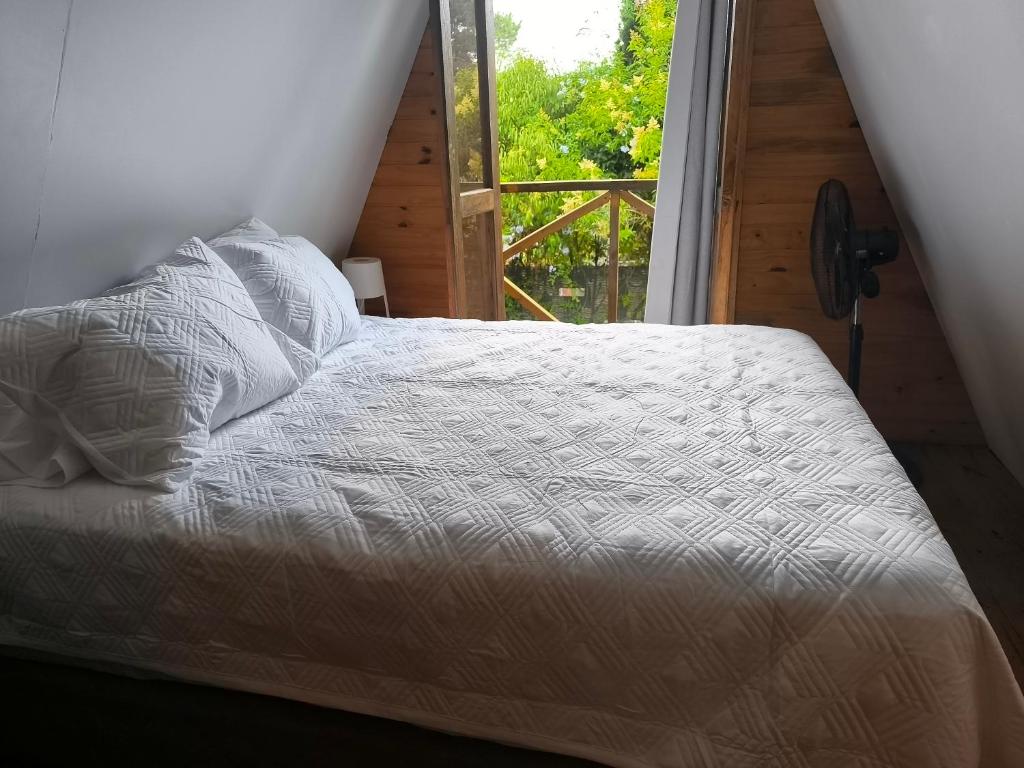 een bed in een kamer met een raam bij Per a Tu in Punta del Este