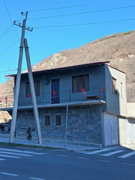 een gebouw met een balkon met rode bloemen erop bij Elite Guest House in Goris