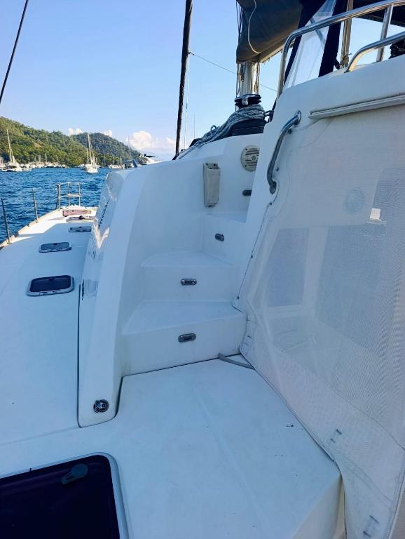 a white boat with a bench on the side at catamaran yatch tour in Göcek