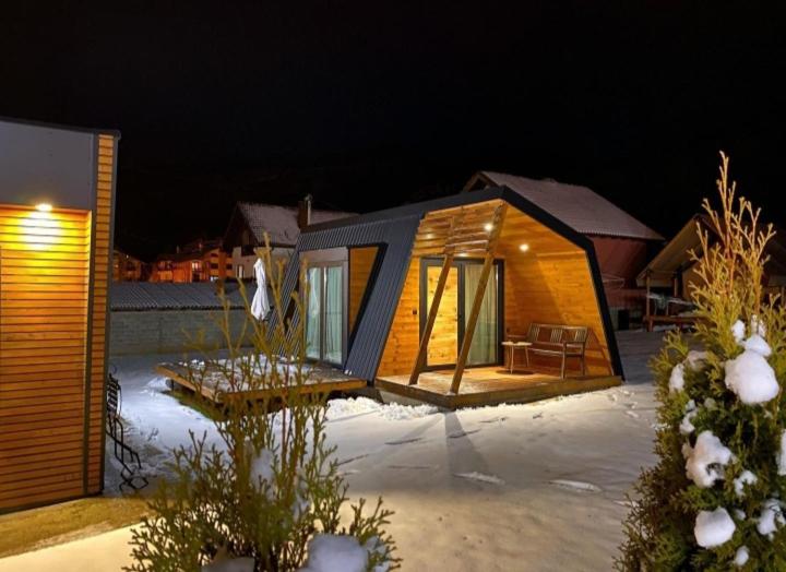 een klein huis in de sneeuw 's nachts bij Vila Ivana in Sirogojno
