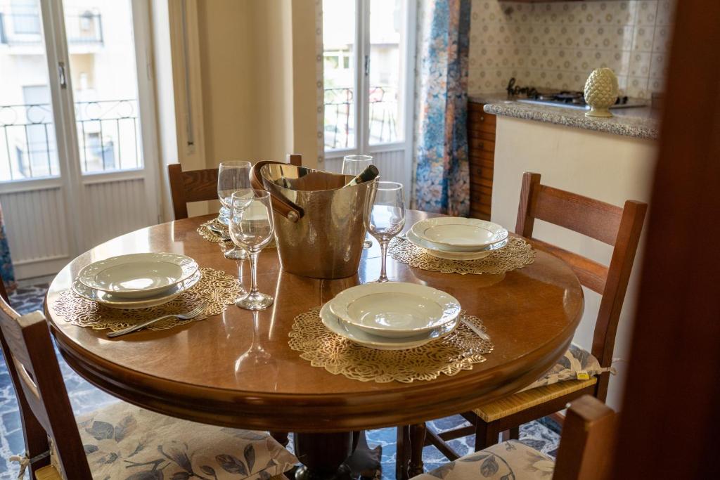 un tavolo di legno con sopra piatti e bicchieri da vino di Sperlonga Center Home a Sperlonga