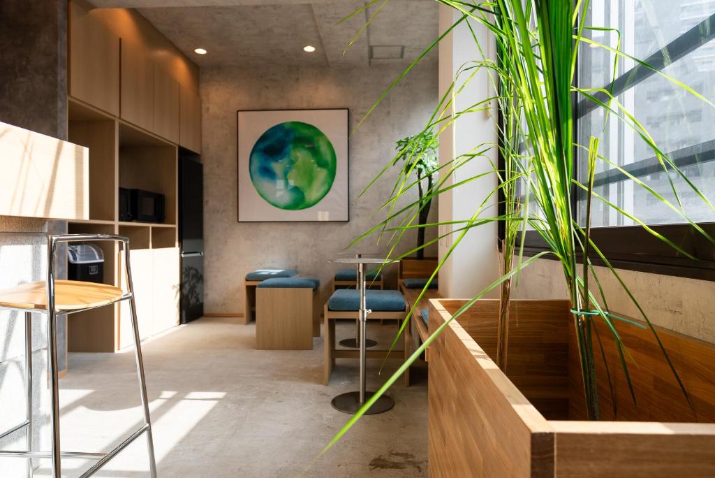 a room with a table and chairs and a plant at Wa Hostel in Tokyo