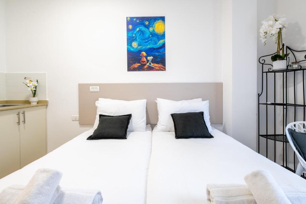 ein Schlafzimmer mit einem weißen Bett und zwei Kissen in der Unterkunft Da Vinci in Jerusalem