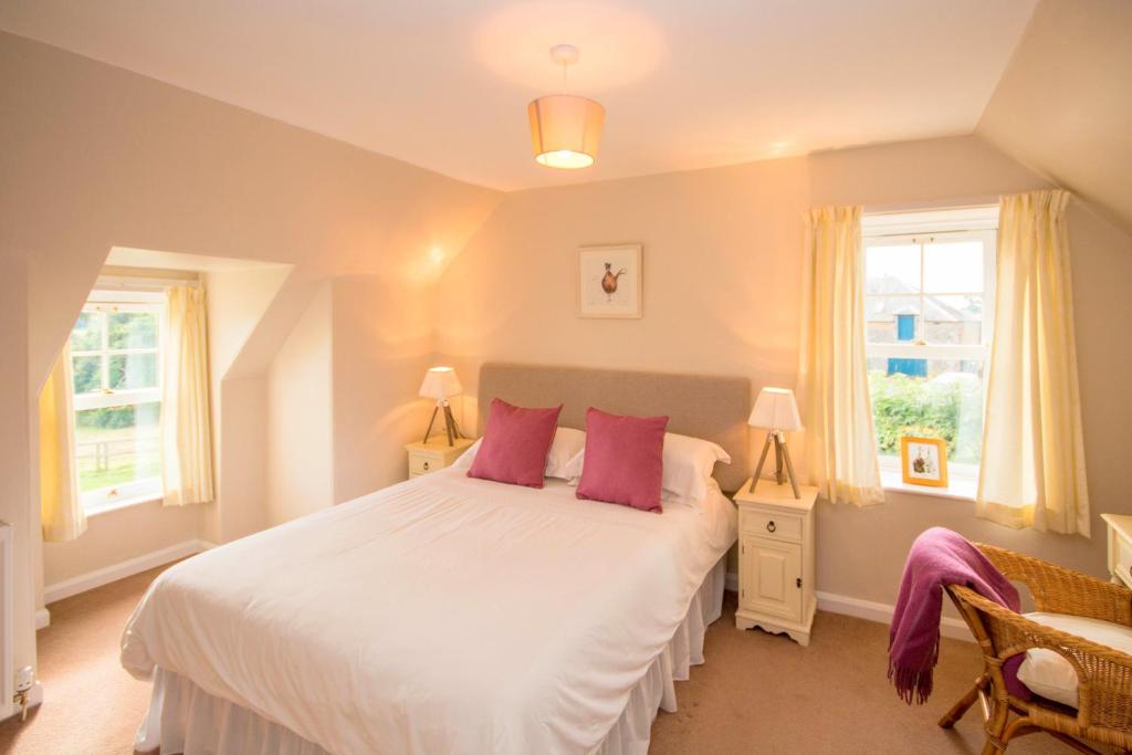 1 dormitorio con 1 cama blanca grande con almohadas rosas en The Lodge, en Kelso