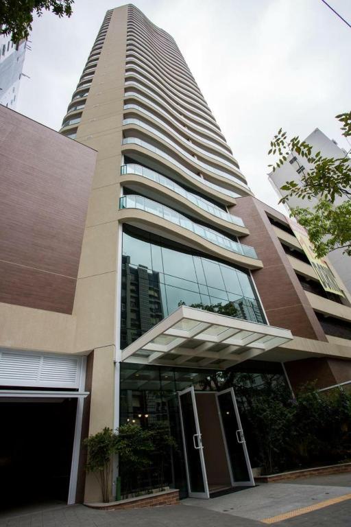 a tall building with a revolving door in front of it at Book Santos - Apartamentos no Unique Residence in Santos