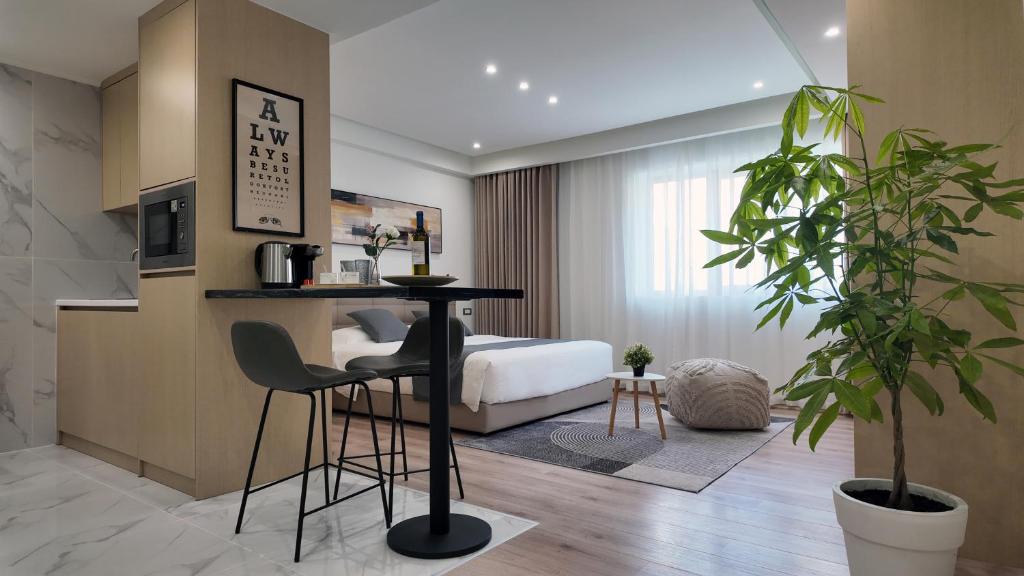 een slaapkamer met een bed, een tafel en stoelen bij CC LUX Suites in Piraeus Port in Piraeus