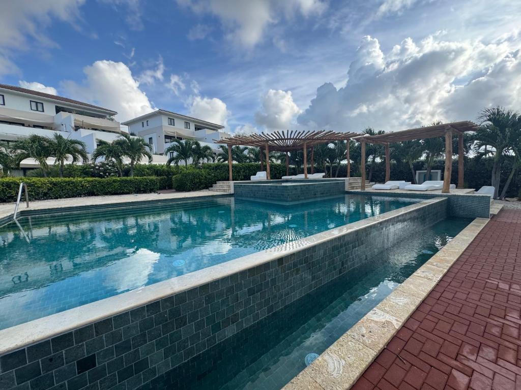 een zwembad met een paviljoen naast een gebouw bij Blauw Geluk I - At Blue Bay Curaçao in Blauw Baai