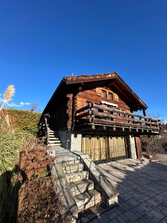 una vecchia baita di tronchi con scale che conducono ad essa di Chalet à Savièse en bordure de forêt a Savièse