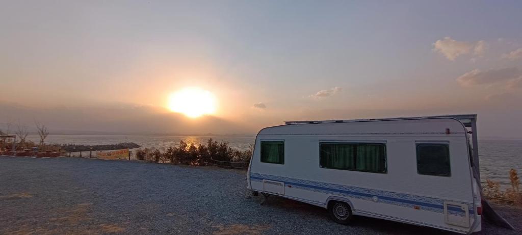 a white camper parked in front of a sunset at 노을이 아름다운 호미곶 캠핑카 in Sup'sil