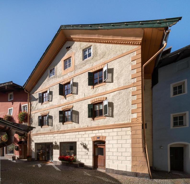 a large brick building with black shuttered windows at Resi´s Stadthaus in Kitzbühel