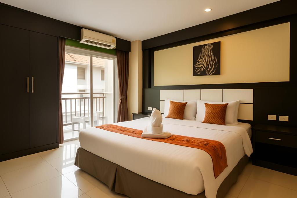 a bedroom with a large bed and a balcony at The Star House in Patong Beach