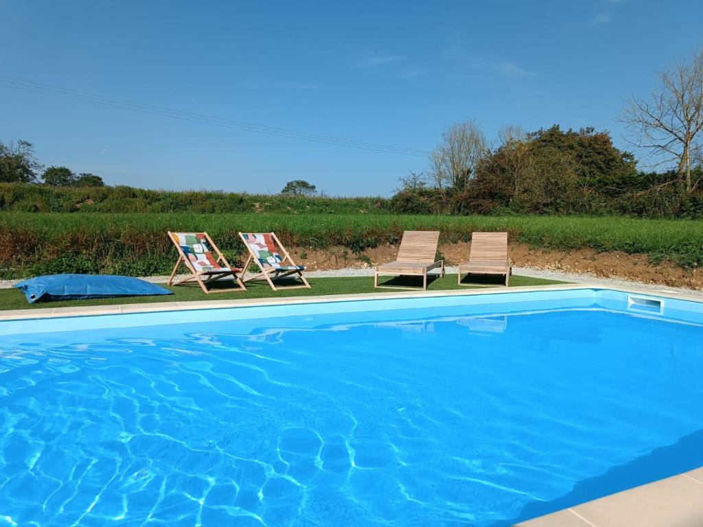 - deux chaises et une piscine dans la cour dans l'établissement 4 minutes from Sainte-Mère-Église - Independent apartment on first floor of big house with garden and heated pool opened if weather is ok, à Fresville