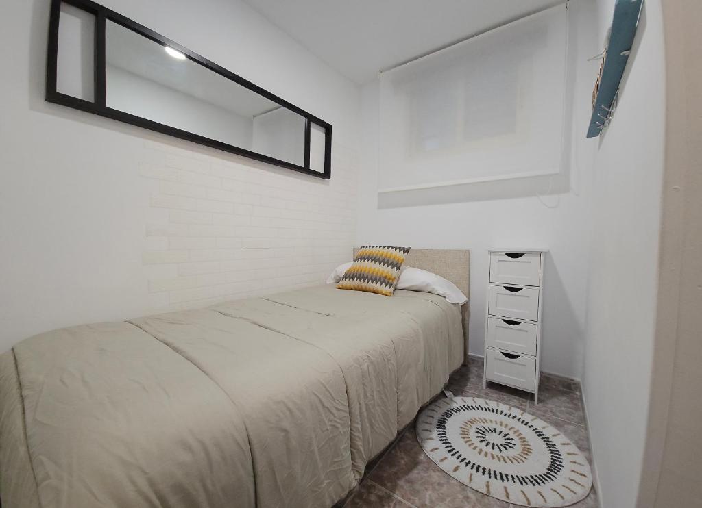 a bedroom with a bed and a mirror on the wall at Residencial Colibrí in Cambrils