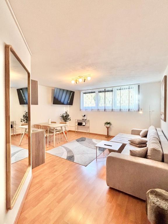 een woonkamer met een bank en een tafel bij Flower House - Souterrain with Garden in Mölbling