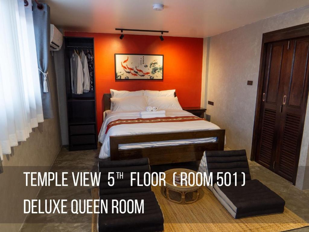 een slaapkamer met een bed met een oranje muur bij Lo-Ha Guest house, Contactless Check-in in Bangkok