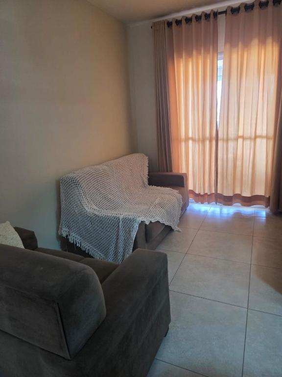 een woonkamer met een bank en een raam bij Beachfront Apartment in Itanhaém