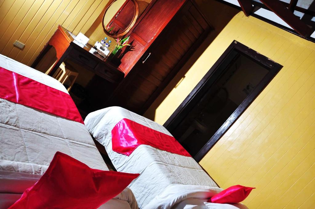 a bedroom with a bed with red pillows on it at Eagle Point Beach and Dive Resort in Mabini